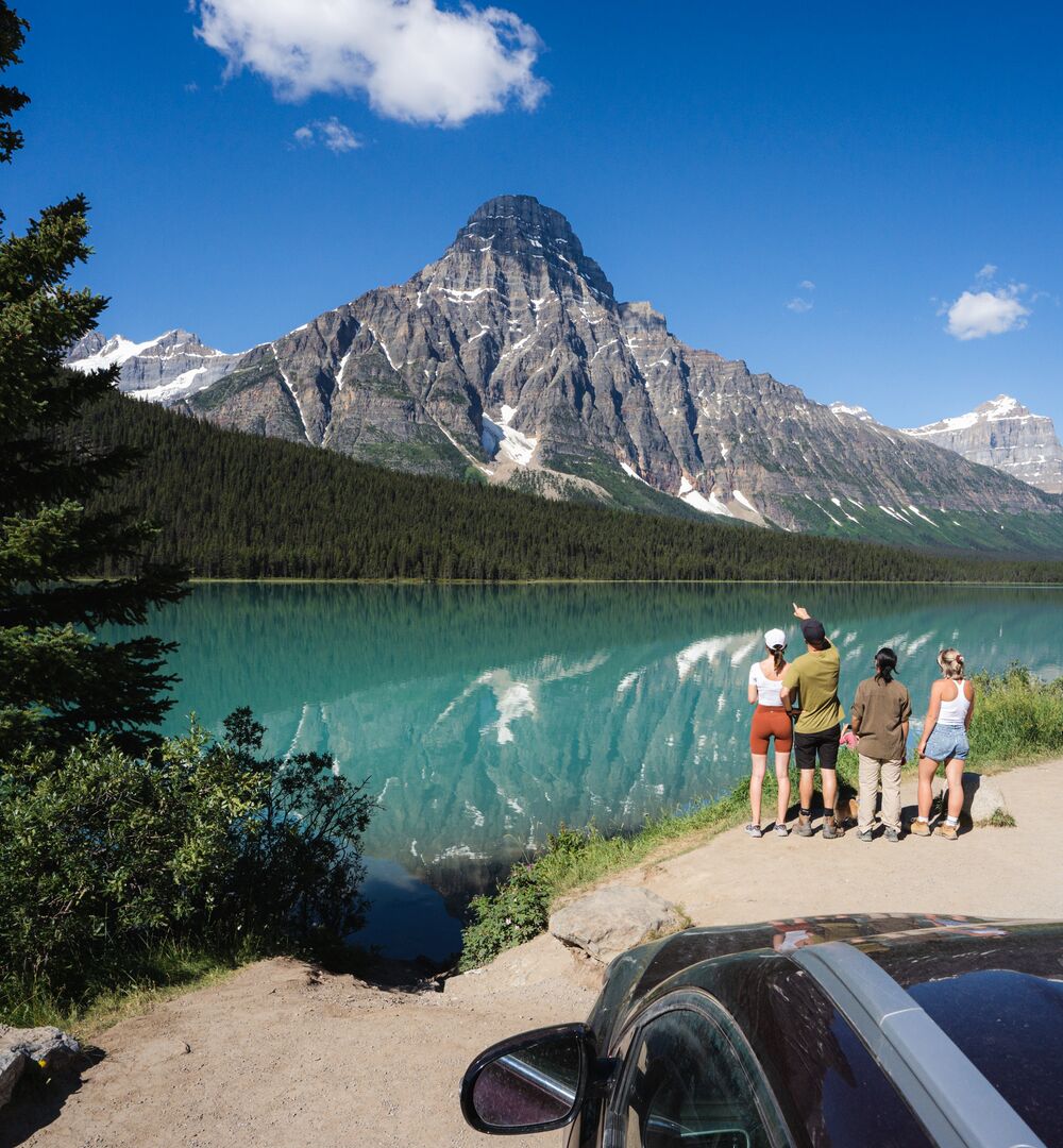 A group of friends taking in the views at Waterfowl Lakes on a drive along the Icefields Parkway in summer